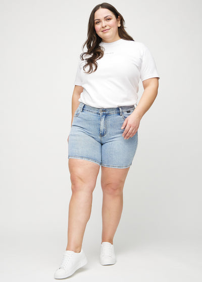 Fuldt billede af en plus-size model i lys denim skinny short shorts.