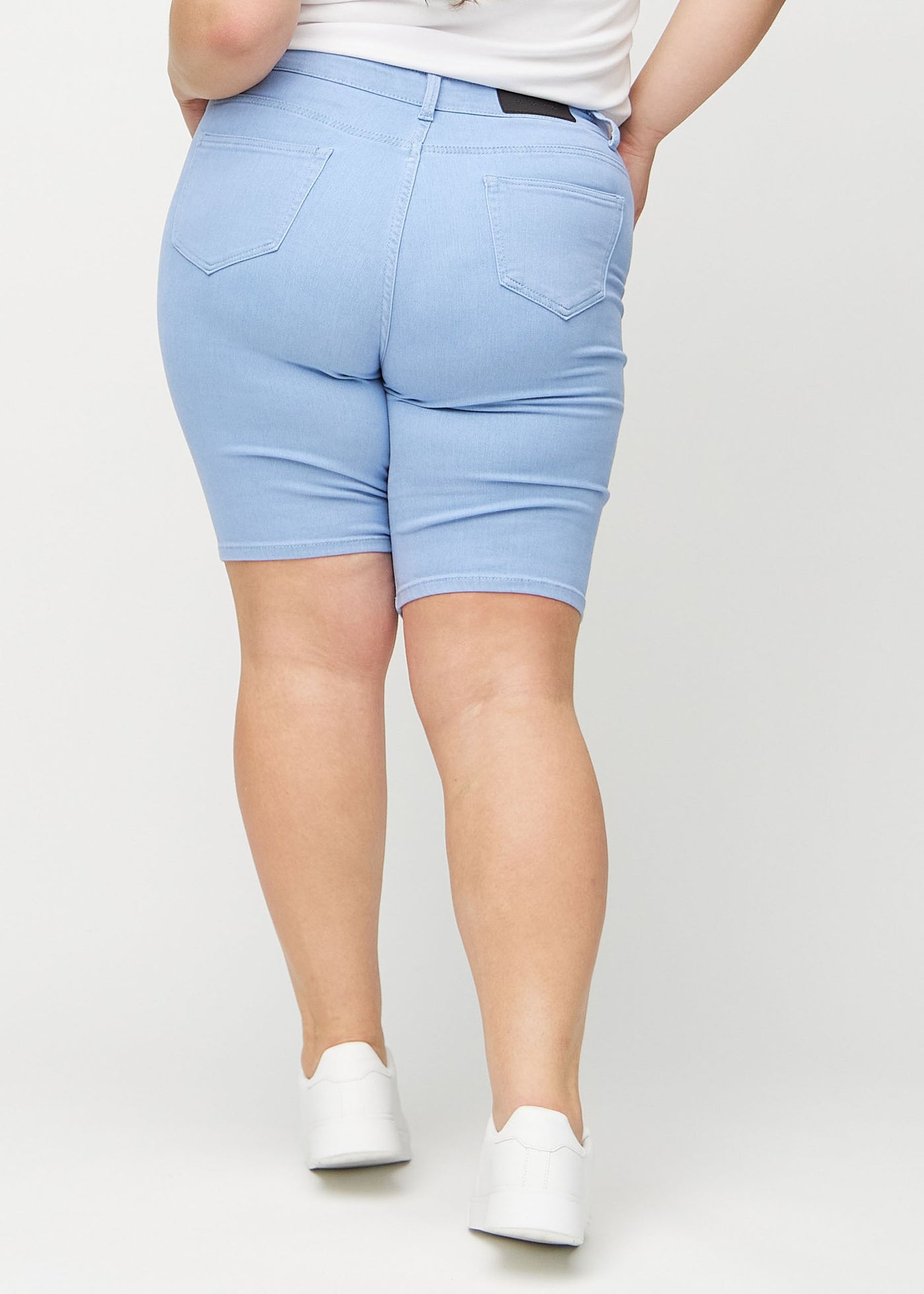 Lyseblå skinny middle shorts set bagfra på en plus-size model, så man kan se hele produktet.