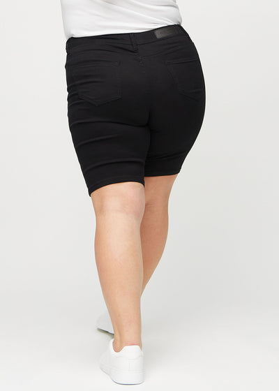 Sorte skinny middle shorts set bagfra på en plus-size model, så man kan se hele produktet.