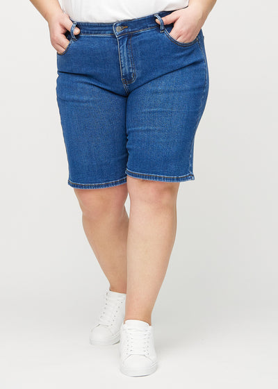 Mørk denim regular middle ultra high rise shorts, modelnavn Oceans, som går lige ned langs benet og sidder højt i taljen på en plus-size model, set forfra.