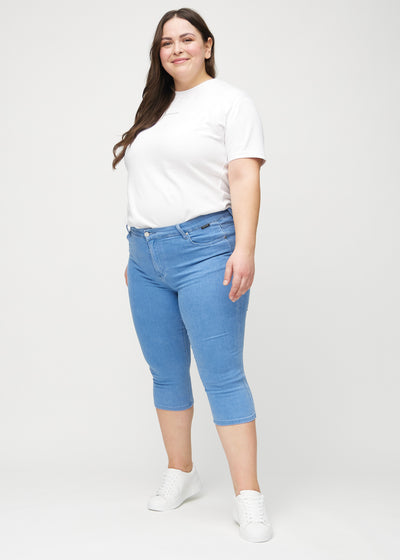 Fuldt billede af en plus-size model i blå skinny capris.