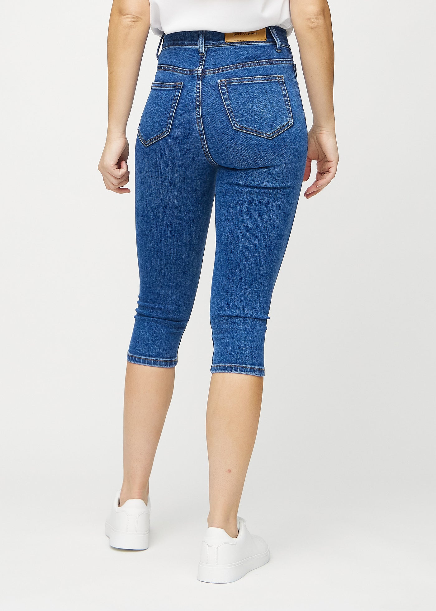 Mørk denim skinny capris set bagfra, så man kan se hele produktet.