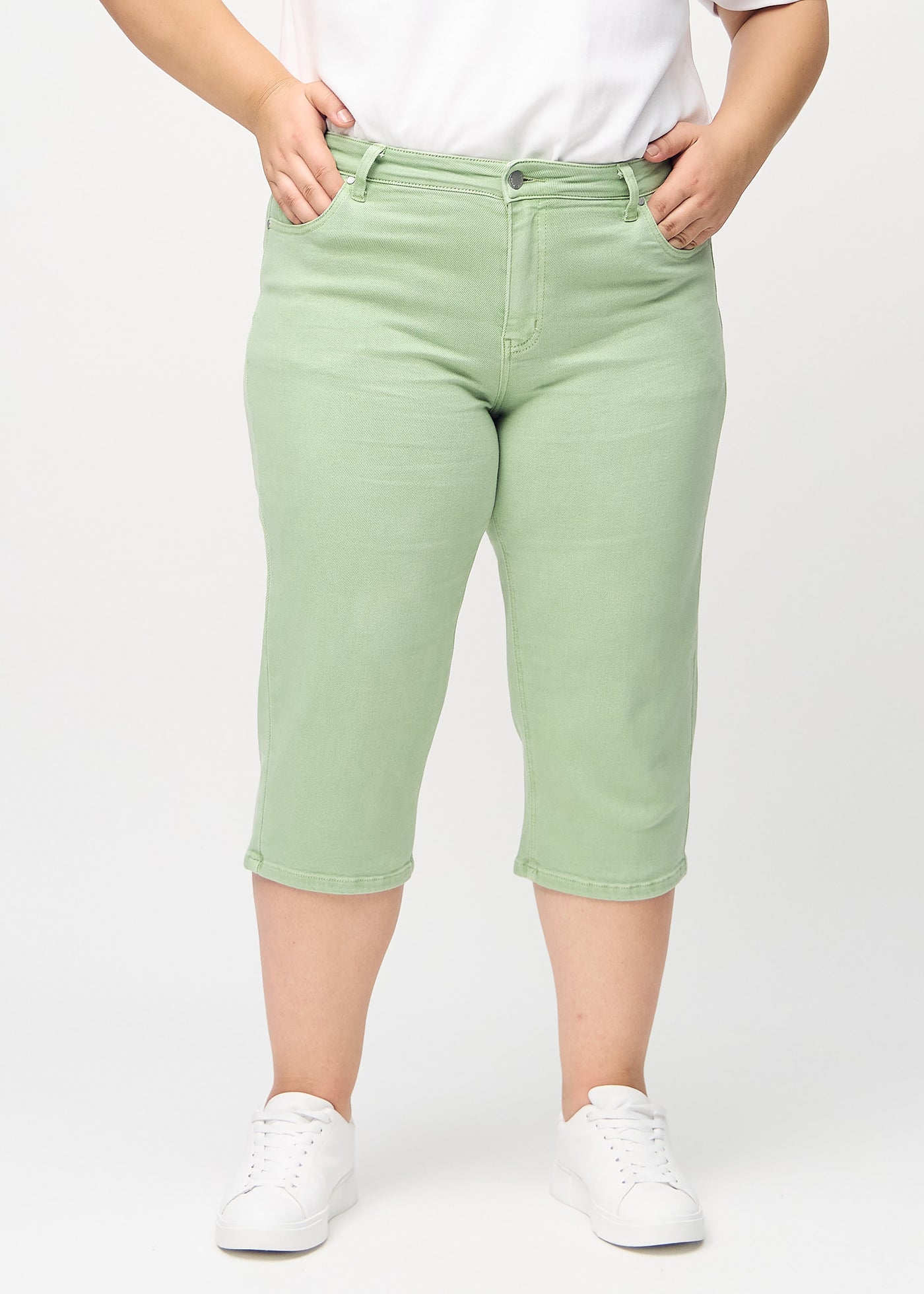 Lysegrønne regular capris, modelnavn Mints, som går lige ned langs benet på en plus-size model, set forfra.