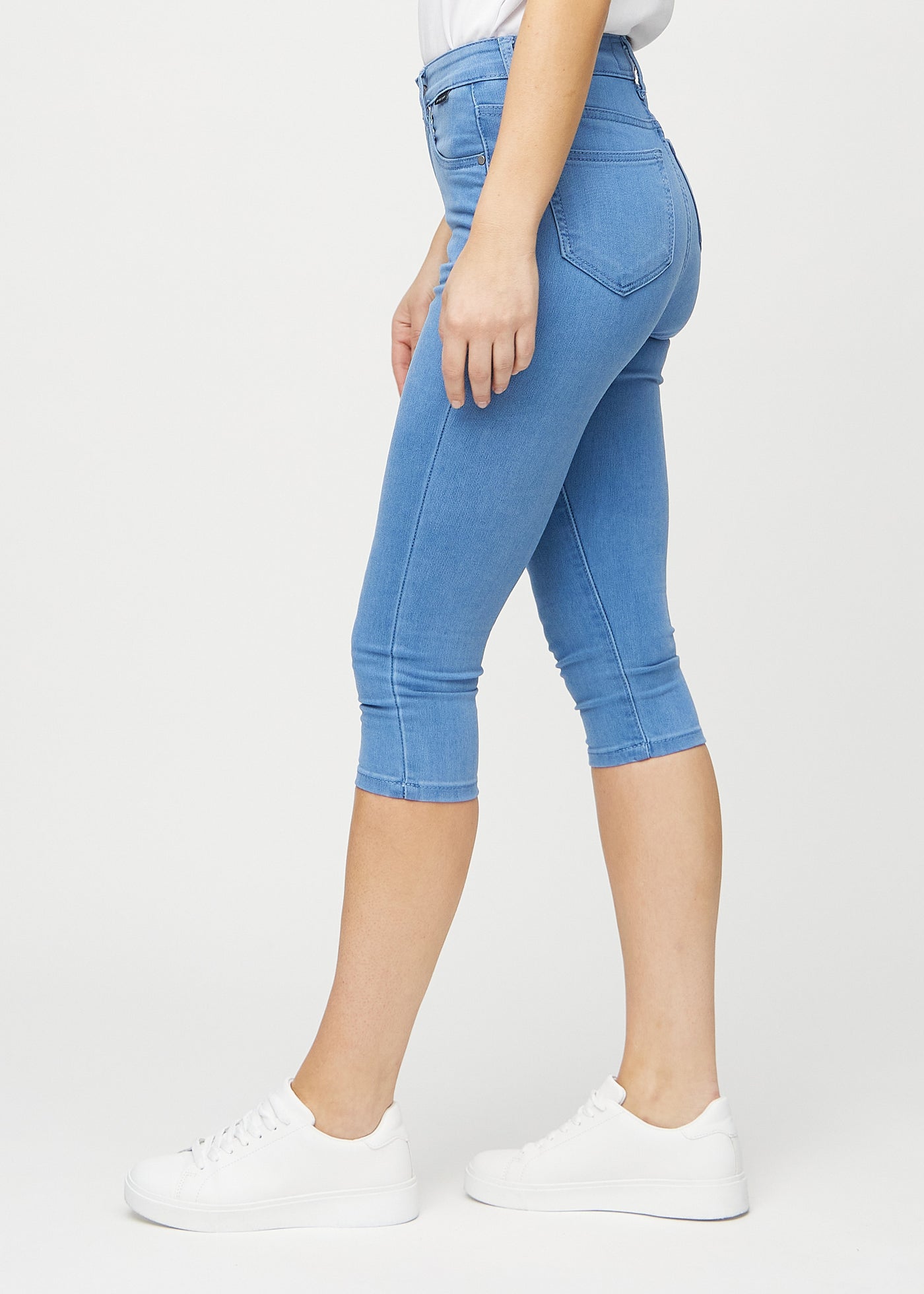 Blå skinny capris set fra siden på model.