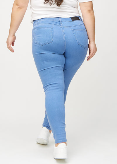 Blå skinny jeans set bagfra på en plus-size model, så man kan se hele produktet.