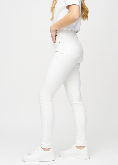 Hvide skinny jeans set fra siden på model.