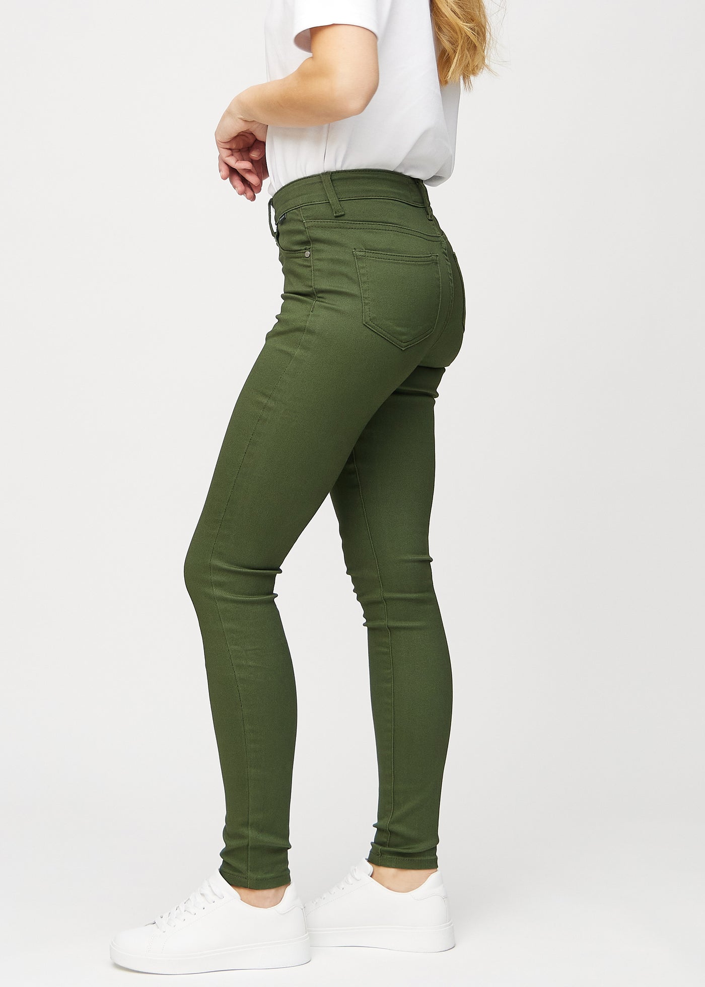 Mørkegrønne skinny jeans set fra siden på model.