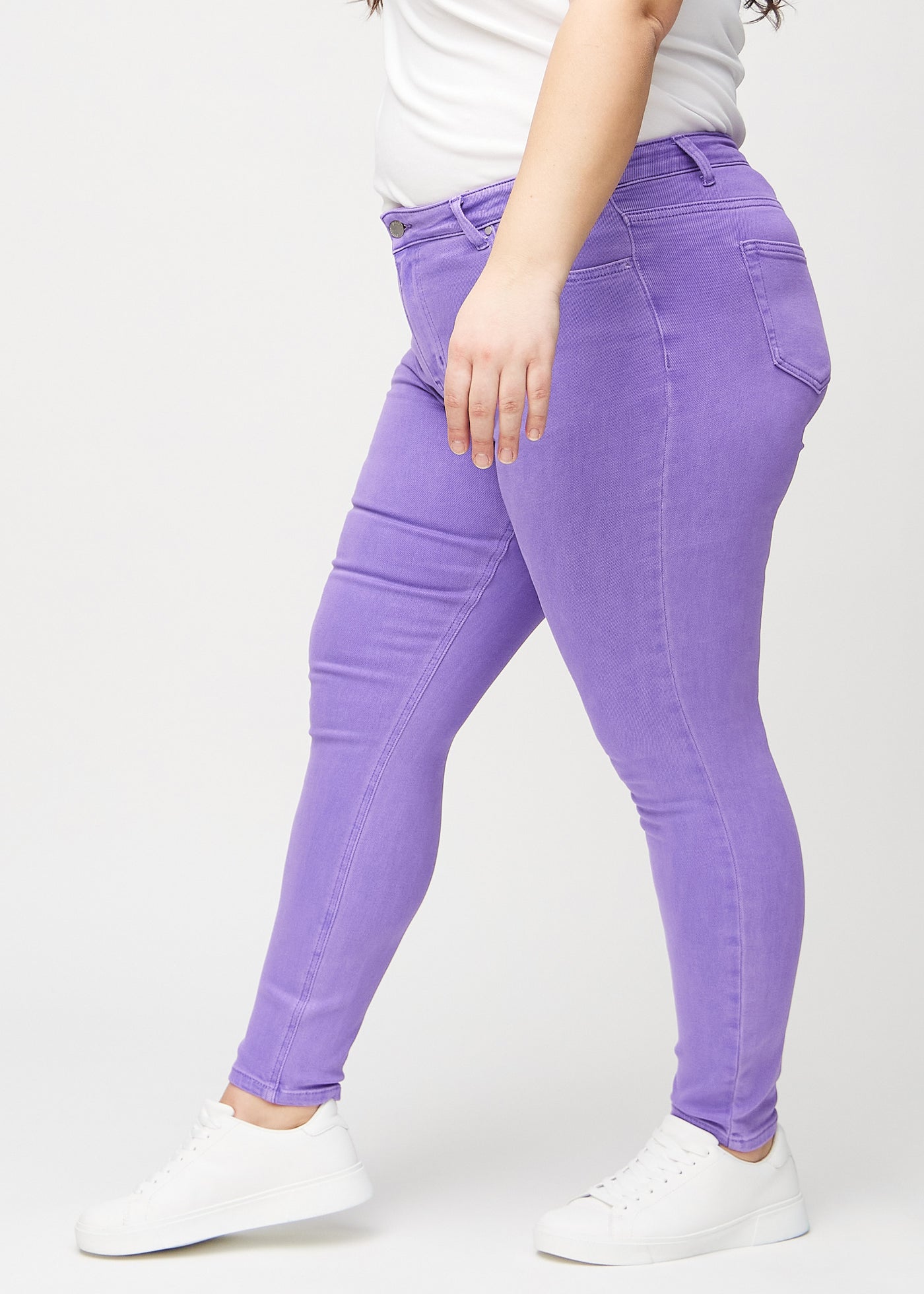 Lilla skinny jeans set fra siden på en plus-size model.