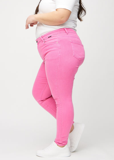 Lyserøde skinny jeans set fra siden på en plus-size model.