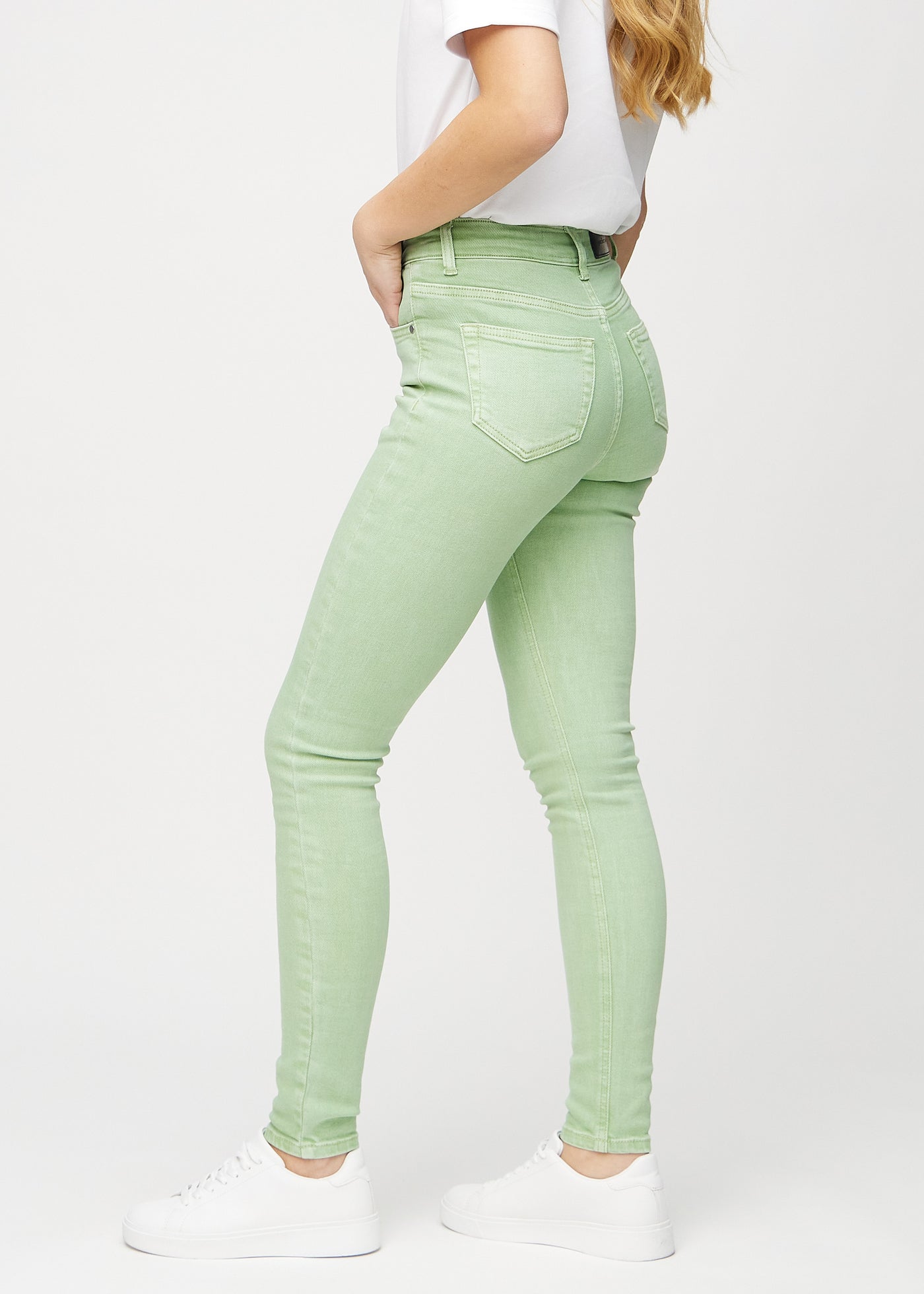 Lysegrønne skinny jeans set fra siden på model.