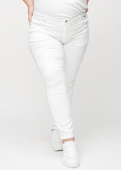 Hvide slim jeans, modelnavn Marguerites, som sidder tæt til benet, dog lidt løsere ved anklen, på en plus-size model, set forfra.