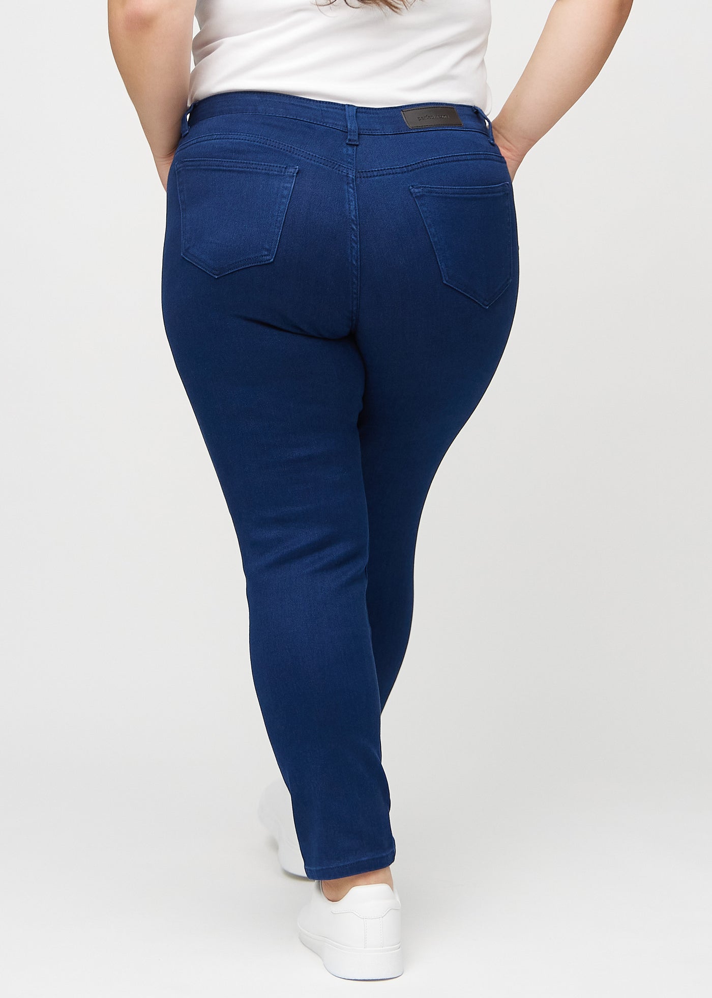 Mørkeblå slim jeans set bagfra på en plus-size model, så man kan se hele produktet.