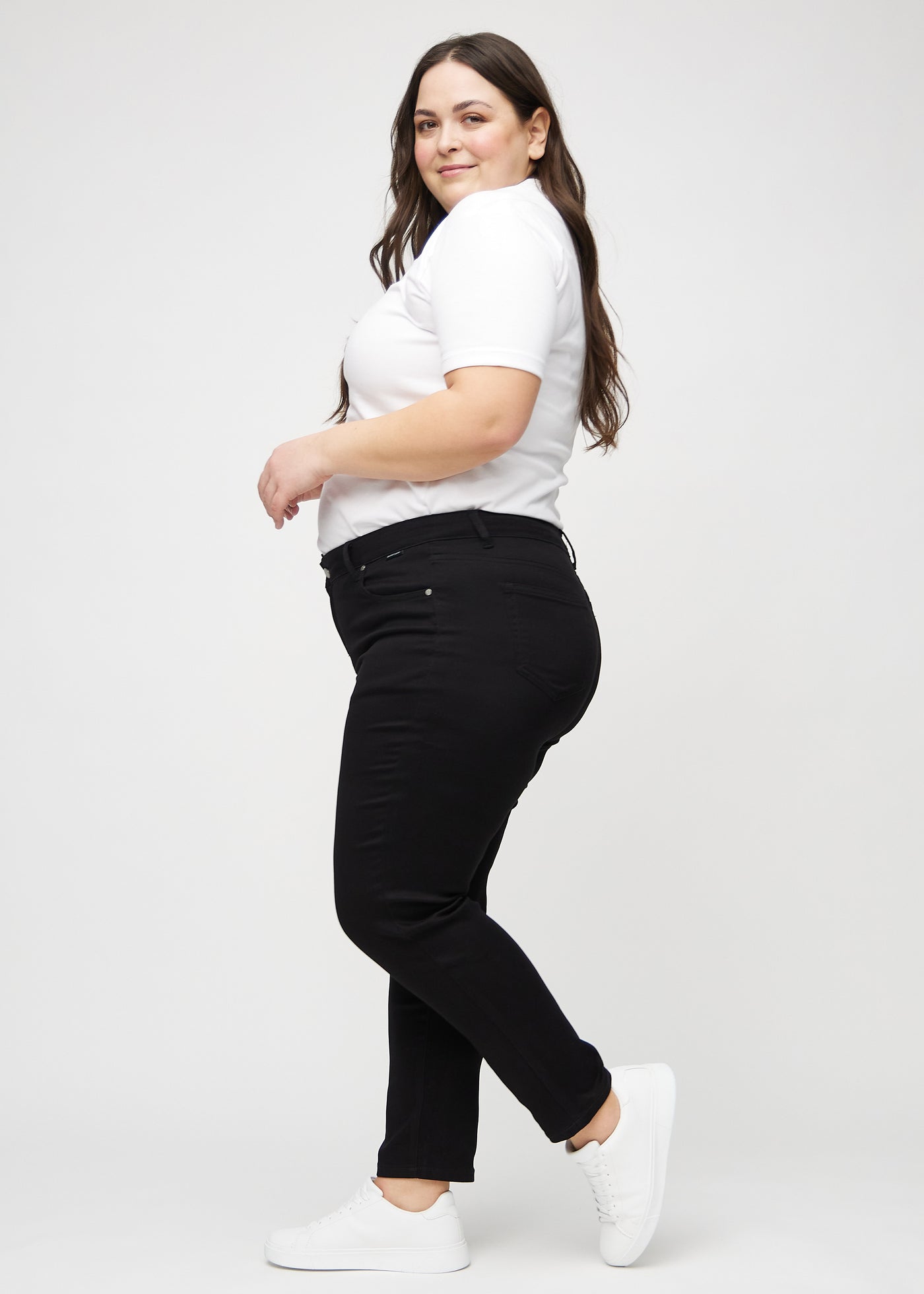 Sorte slim jeans set fra siden på en plus-size model.