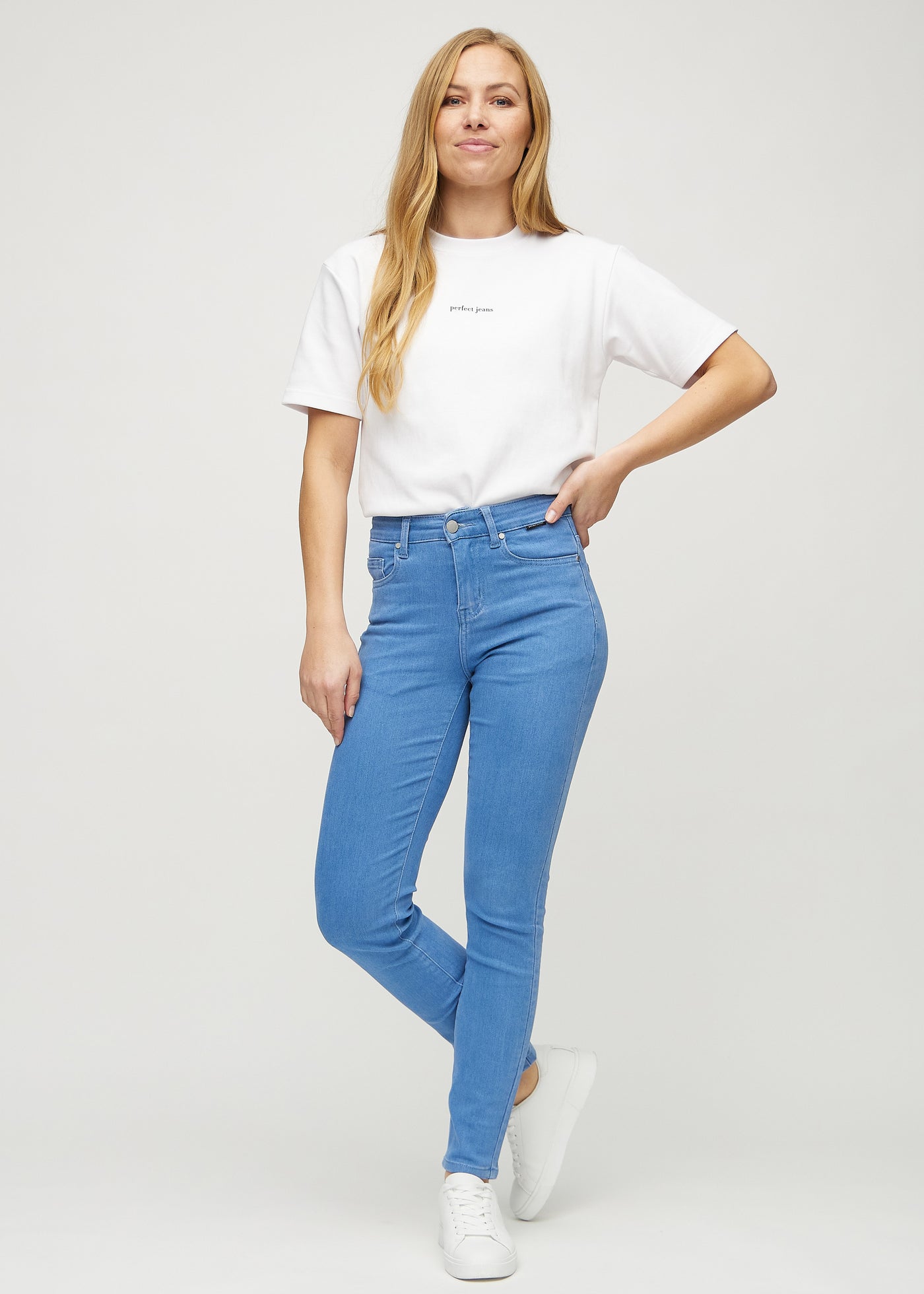 Fuldt billede af model i blå slim jeans.