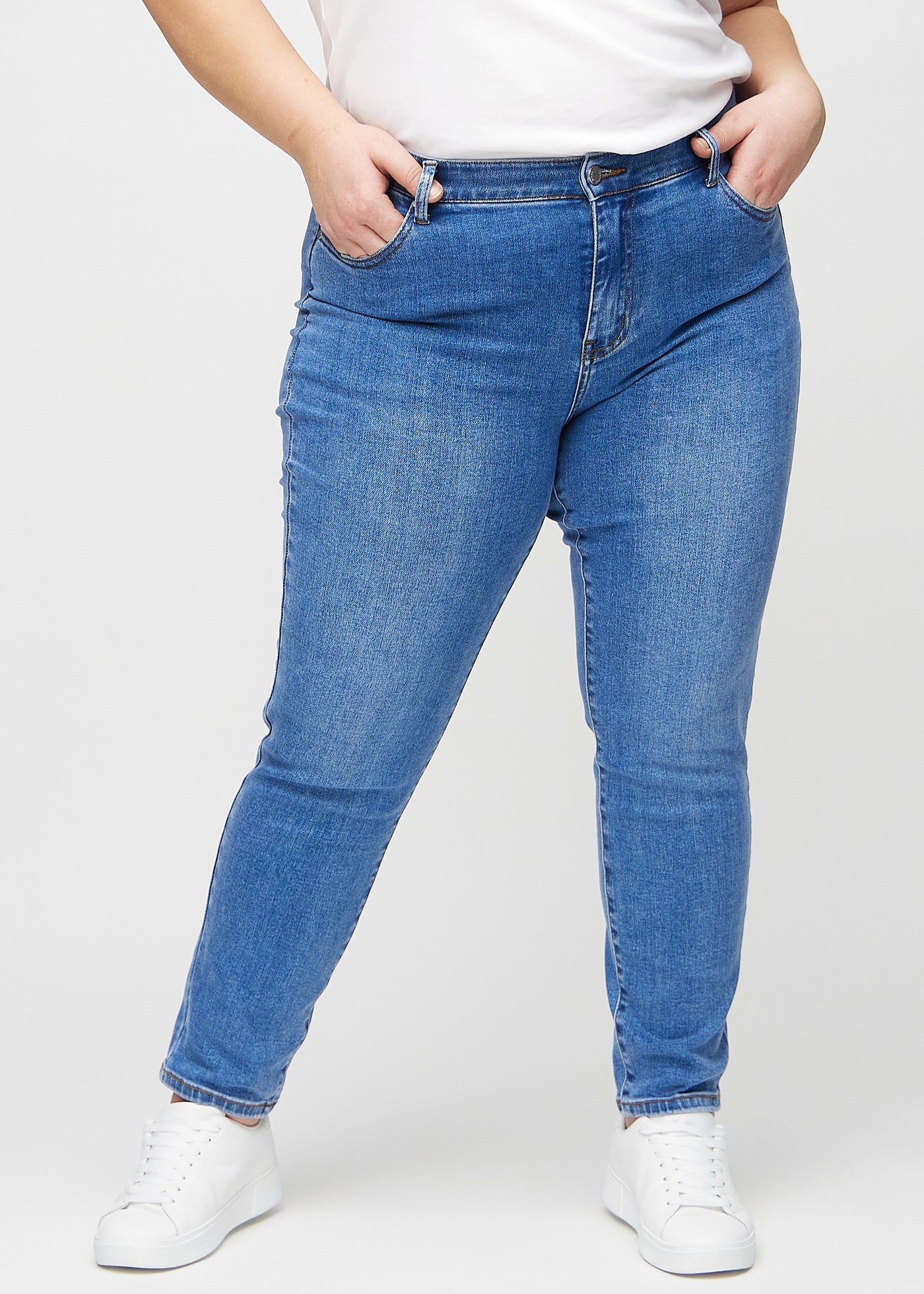 Denim slim ultra high rise jeans, modelnavn Rivers, som sidder tæt til benet og højt i taljen på en plus-size model, set forfra.