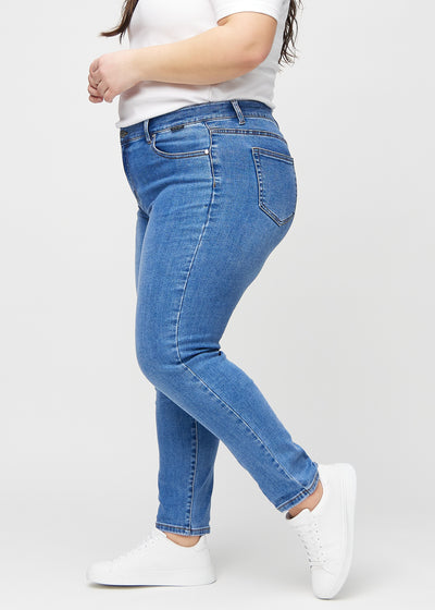 Denim slim ultra high rise jeans set fra siden på en plus-size model.