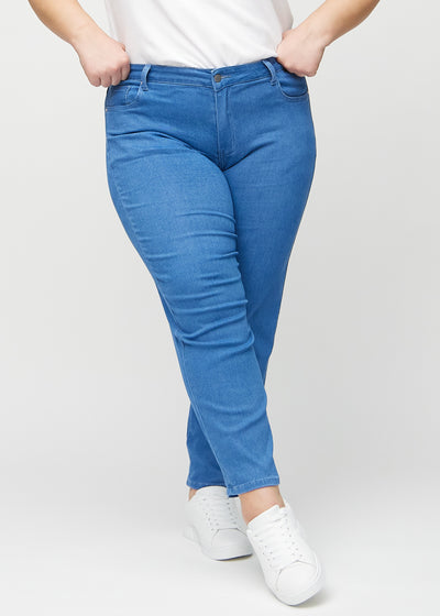 Blå regular jeans, modelnavn Geraniums, som går lige ned langs benet på en plus-size model, set forfra.