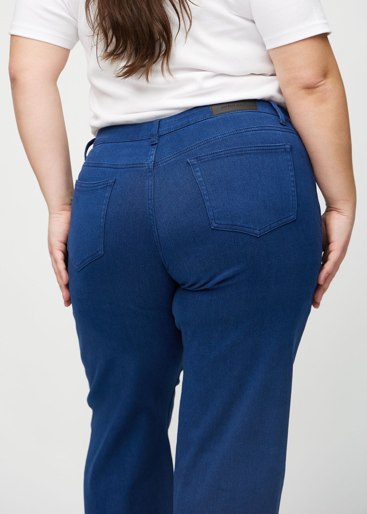 Mørkeblå loose jeans set bagfra tæt på en plus-size model for at vise detaljer.