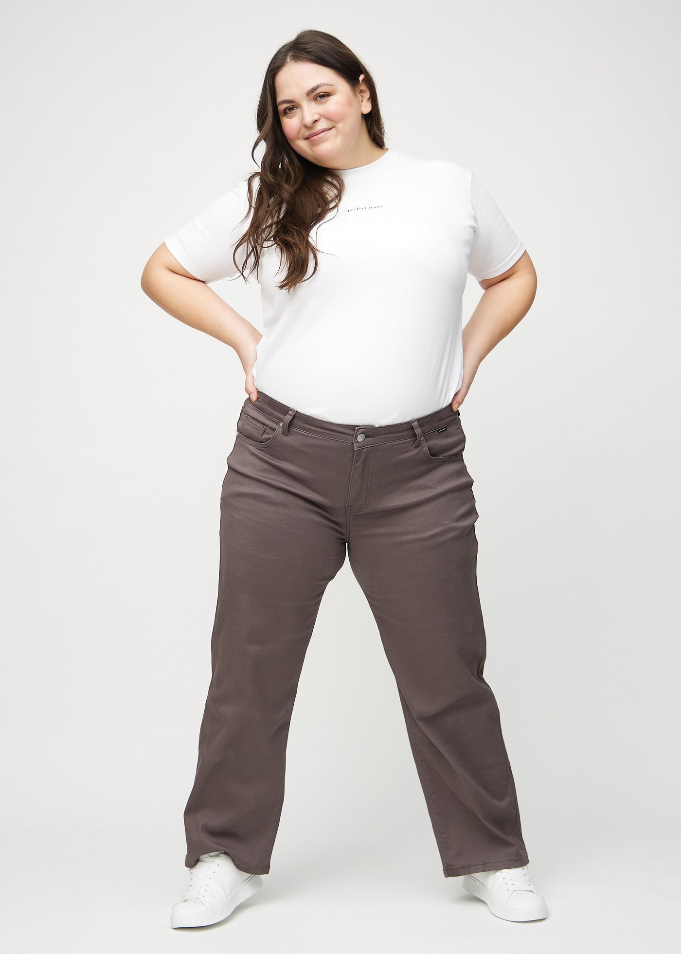 Fuldt billede af en plus-size model i gråbrune loose jeans.