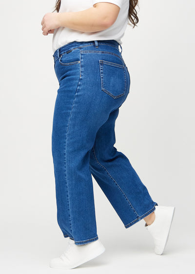 Mørk denim loose jeans set fra siden på en plus-size model.