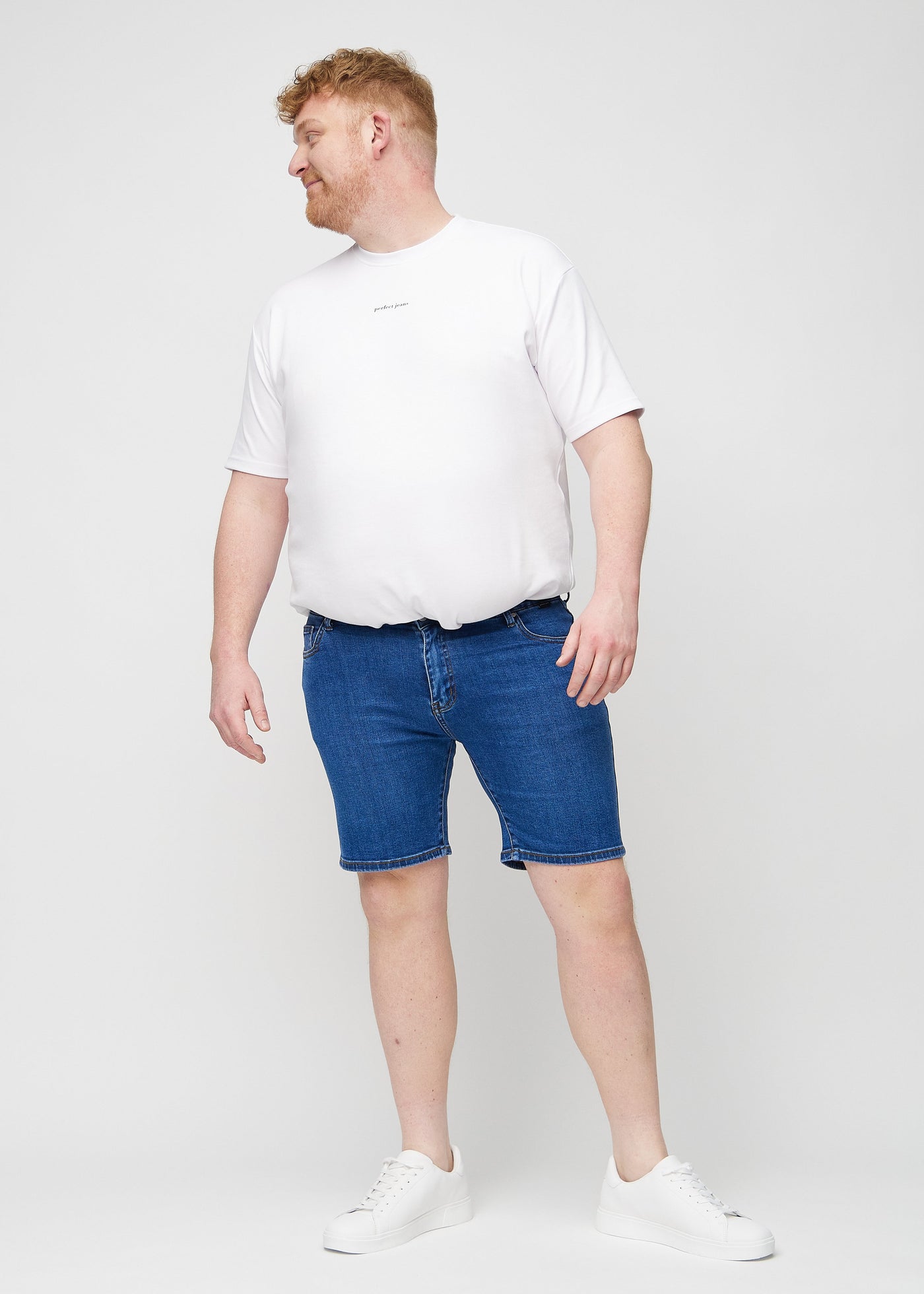 Fuldt billede af en plus-size model i mørk denim regular middle shorts.