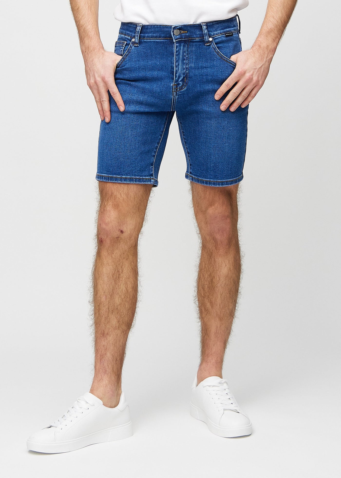 Mørk denim regular middle shorts, som sidder lige langs låret og slutter lige over knæet, set forfra.