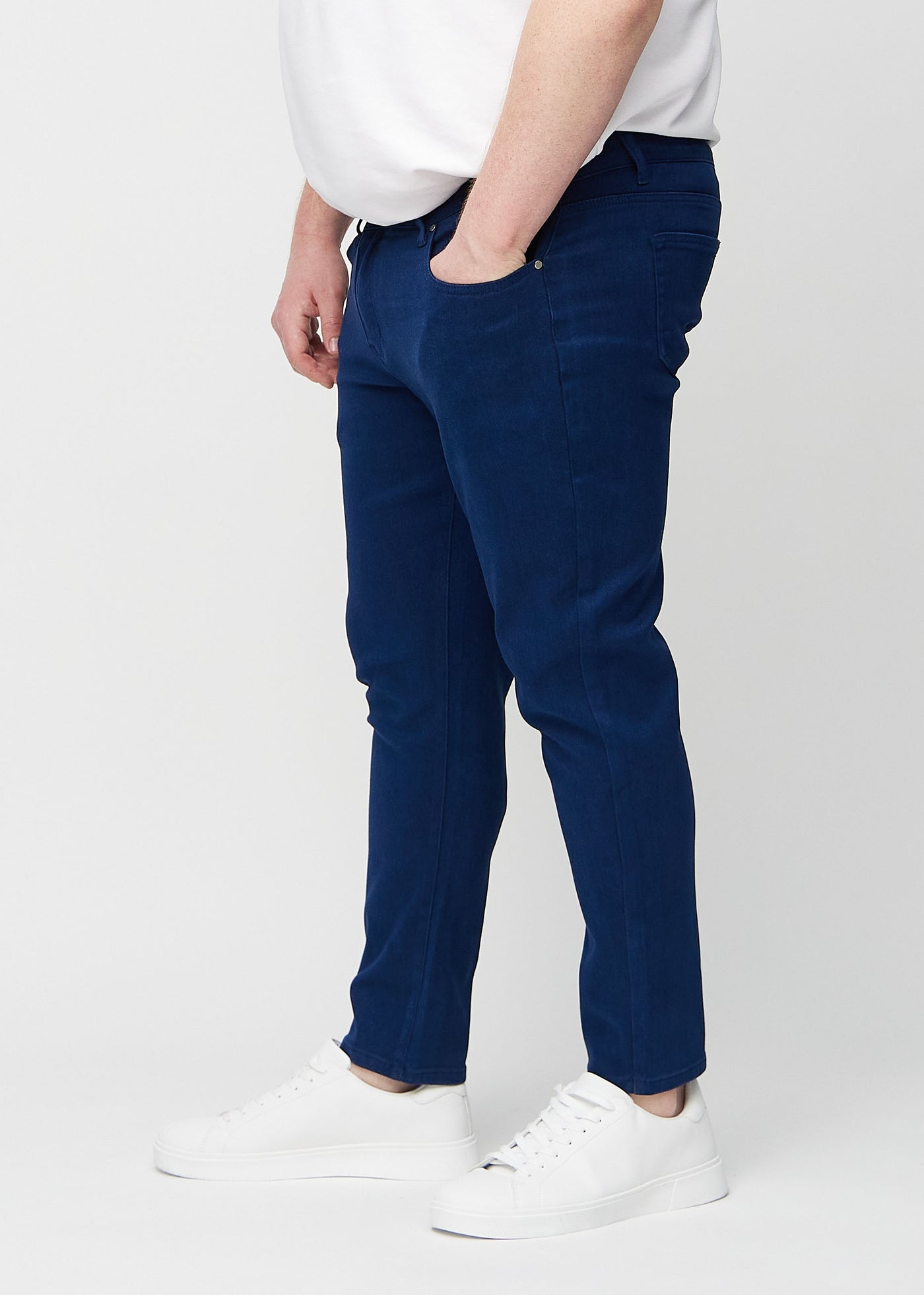 Mørkeblå slim jeans set fra siden på en plus-size model.