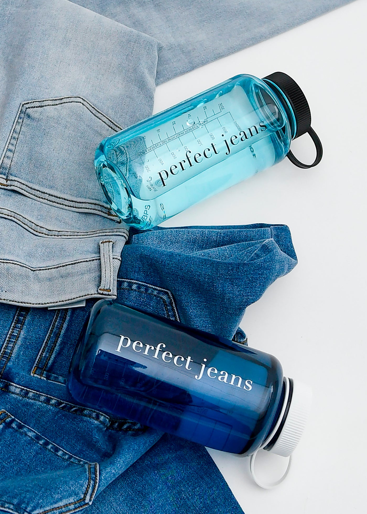 Flatlayer billede af denim jeans og vandflasker fra Perfect Jeans.
