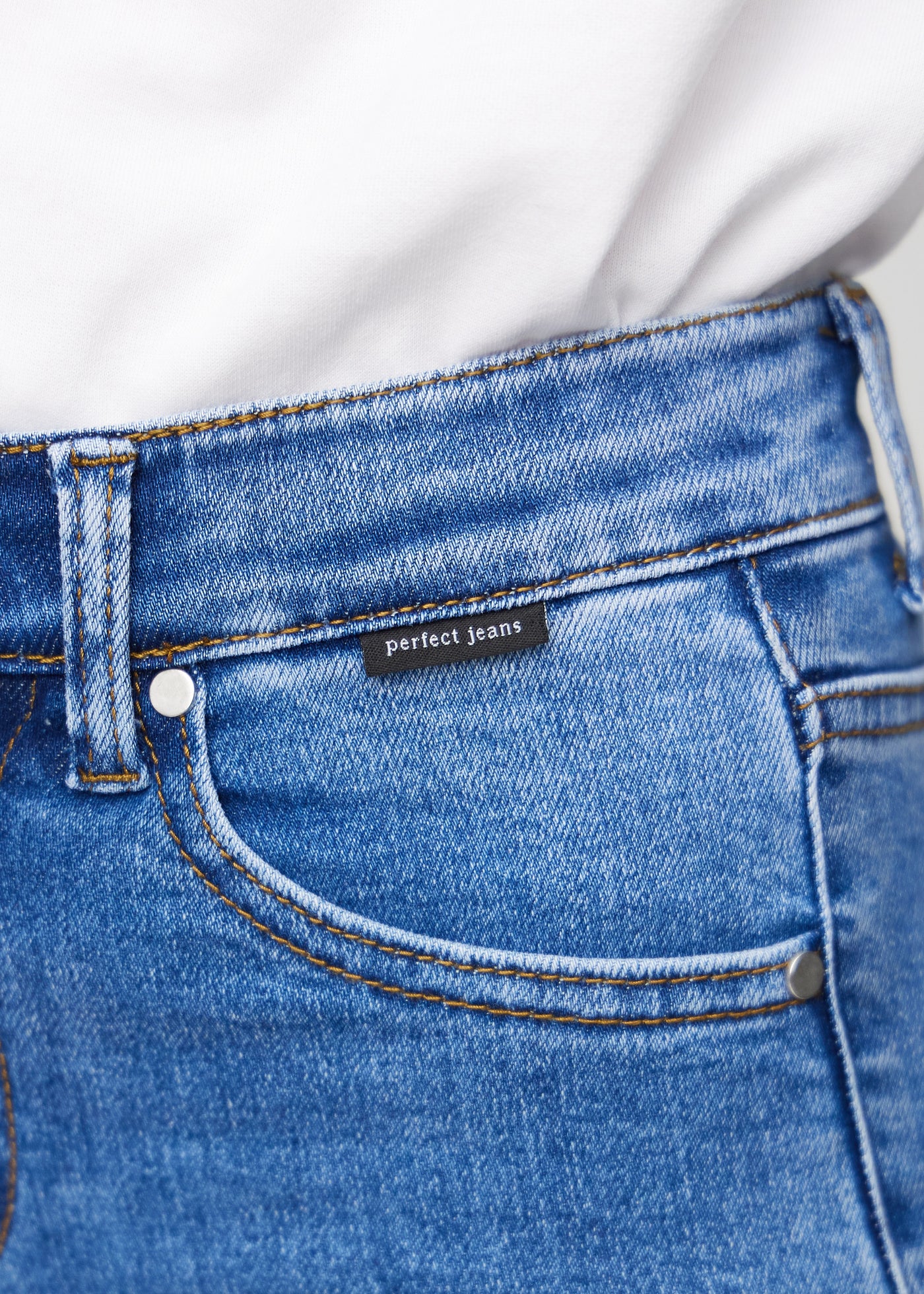 Forlommen på et par denim skinny middle shorts, hvor man kan se logoet.