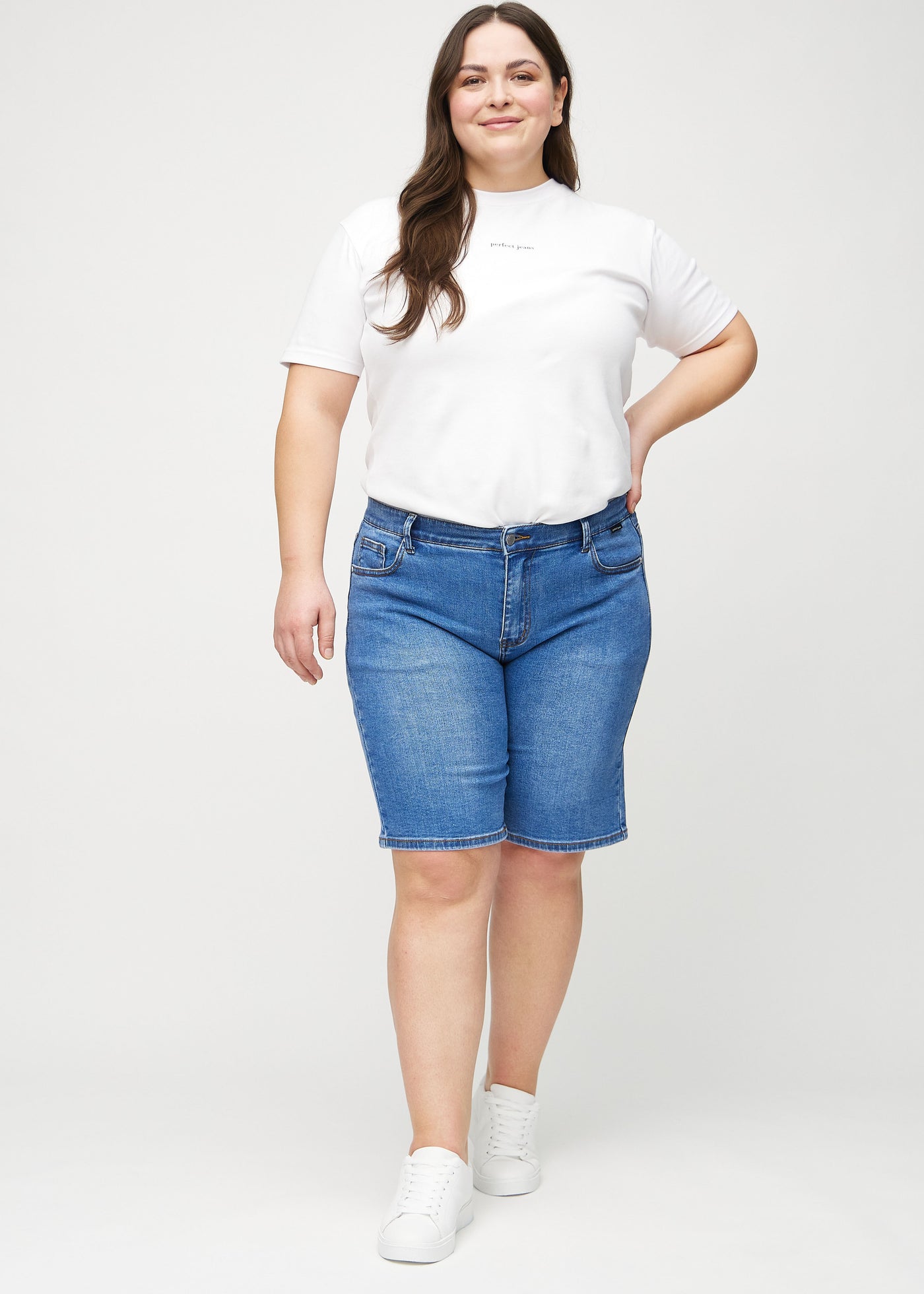 Plus-size model går ind i billedet, strækker i sine shorts, viser dem frem ved at dreje rundt, og forlader derefter billedet.